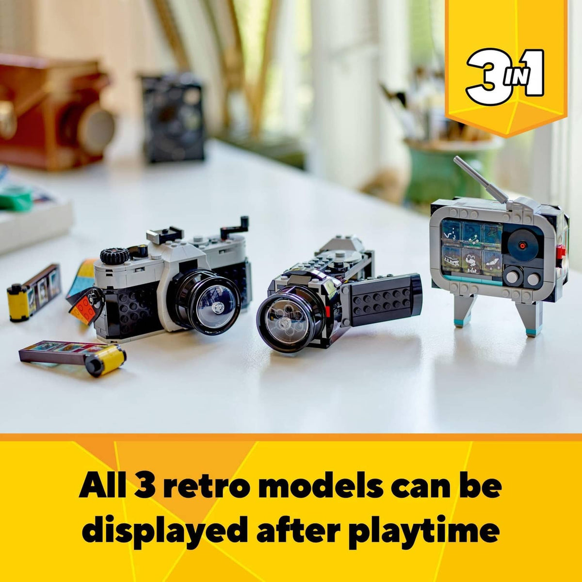 Three LEGO retro camera models with accessories displayed on tabletop