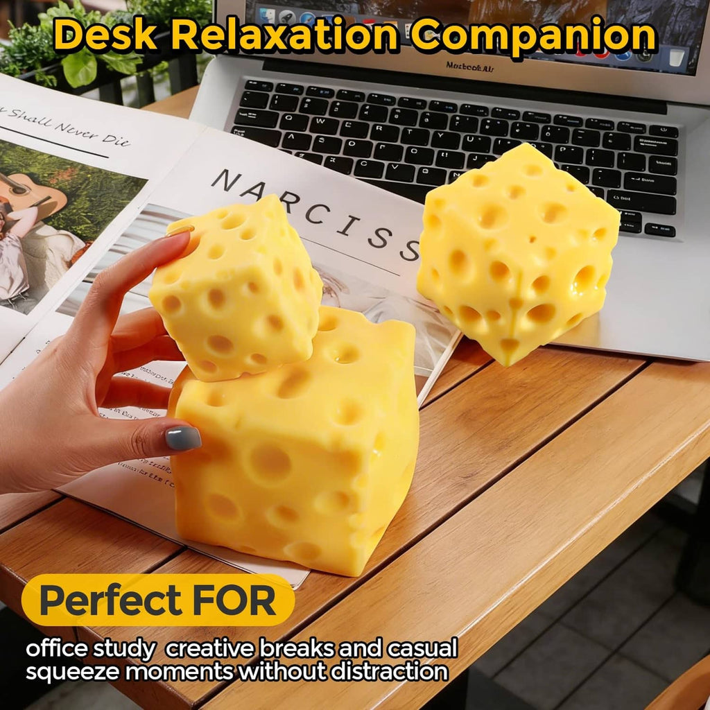Yellow cheese squishy toy cubes with holes, held above a desk