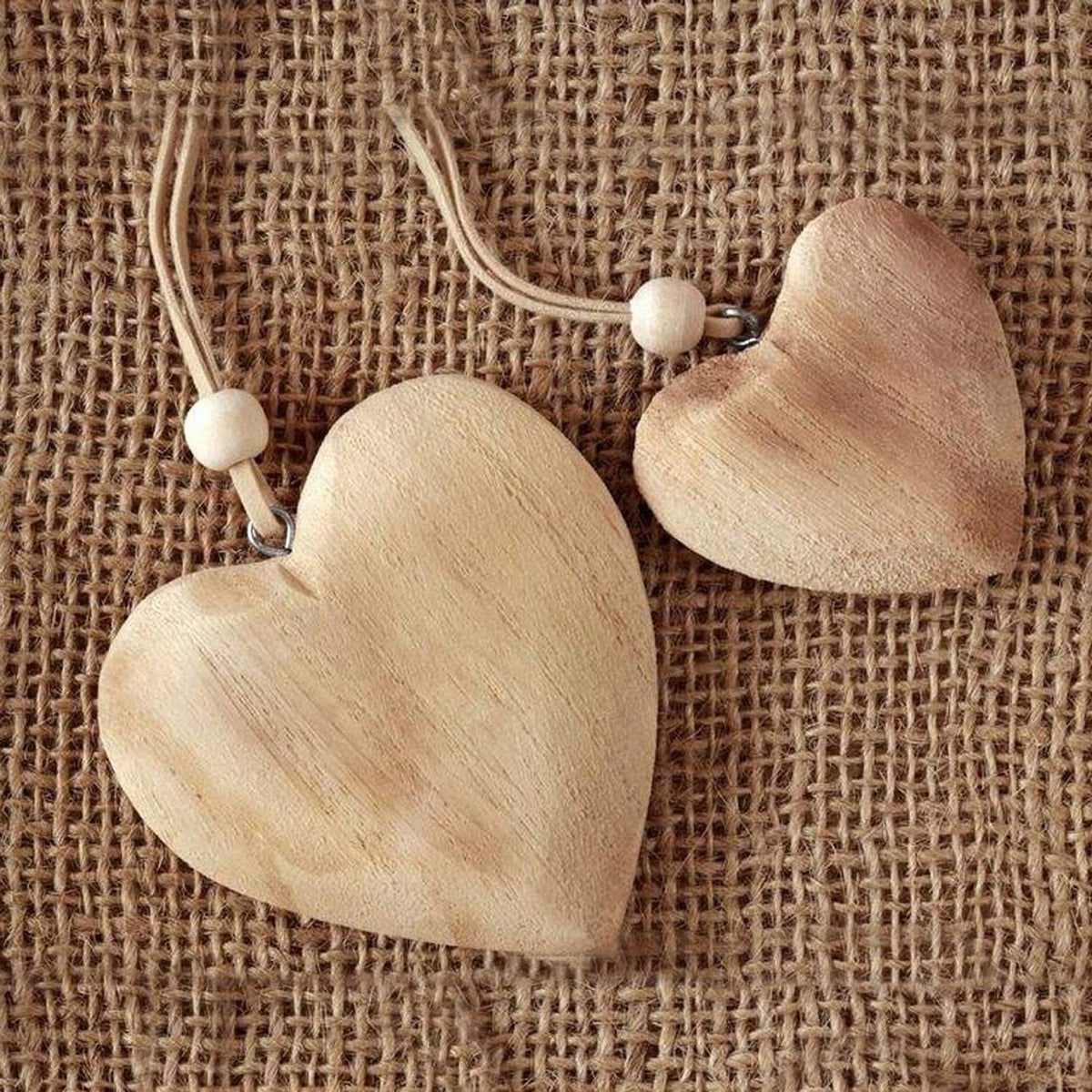 Two wooden heart ornaments on jute string with small bead accents and hanging loops