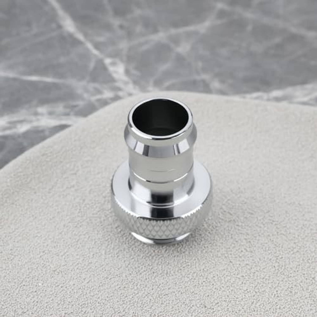 Silver hose barb connector with wide base, textured grip, and dark inner sealing opening