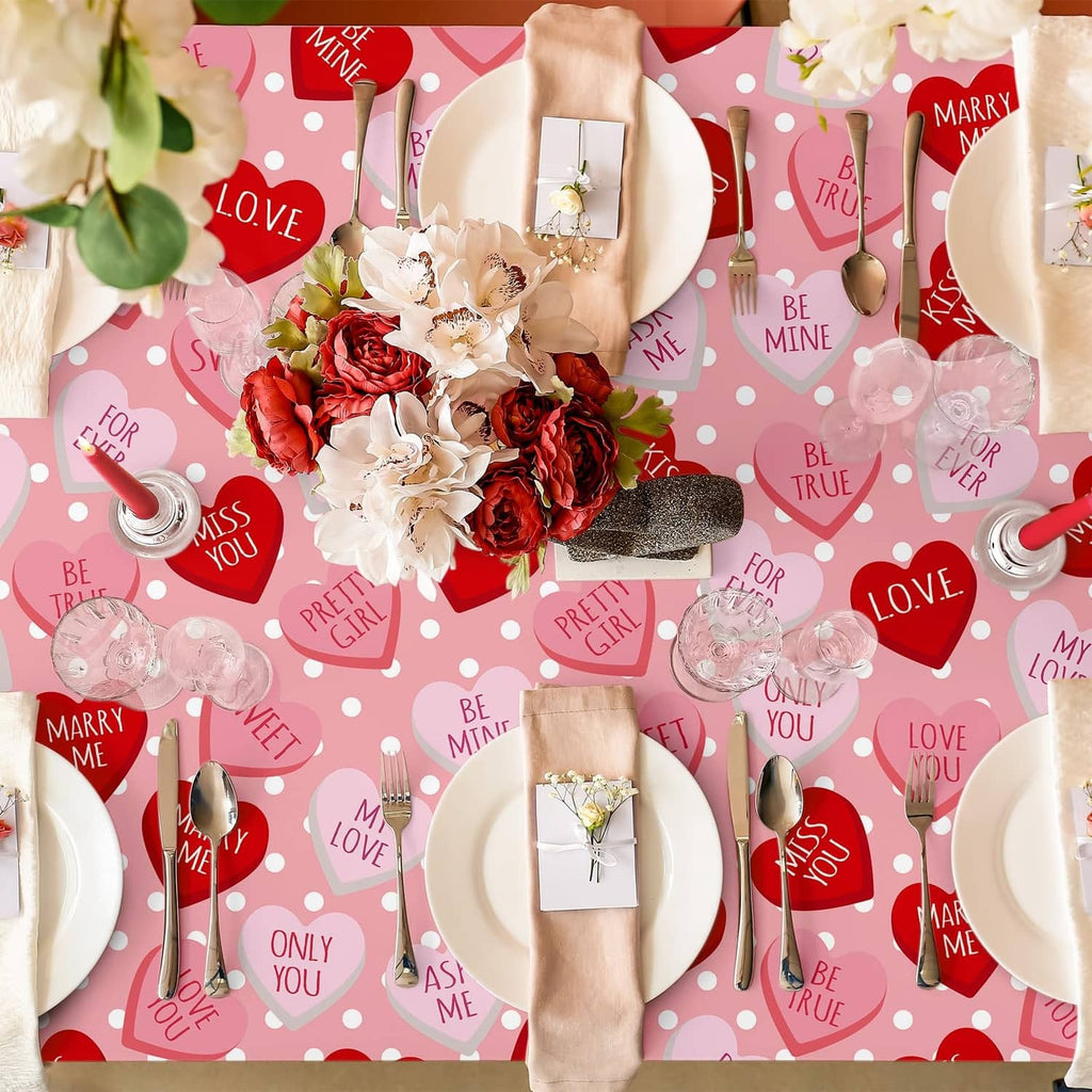 Pink tablecloth flat lay with red hearts, white dots, and assorted Valentine-themed icons