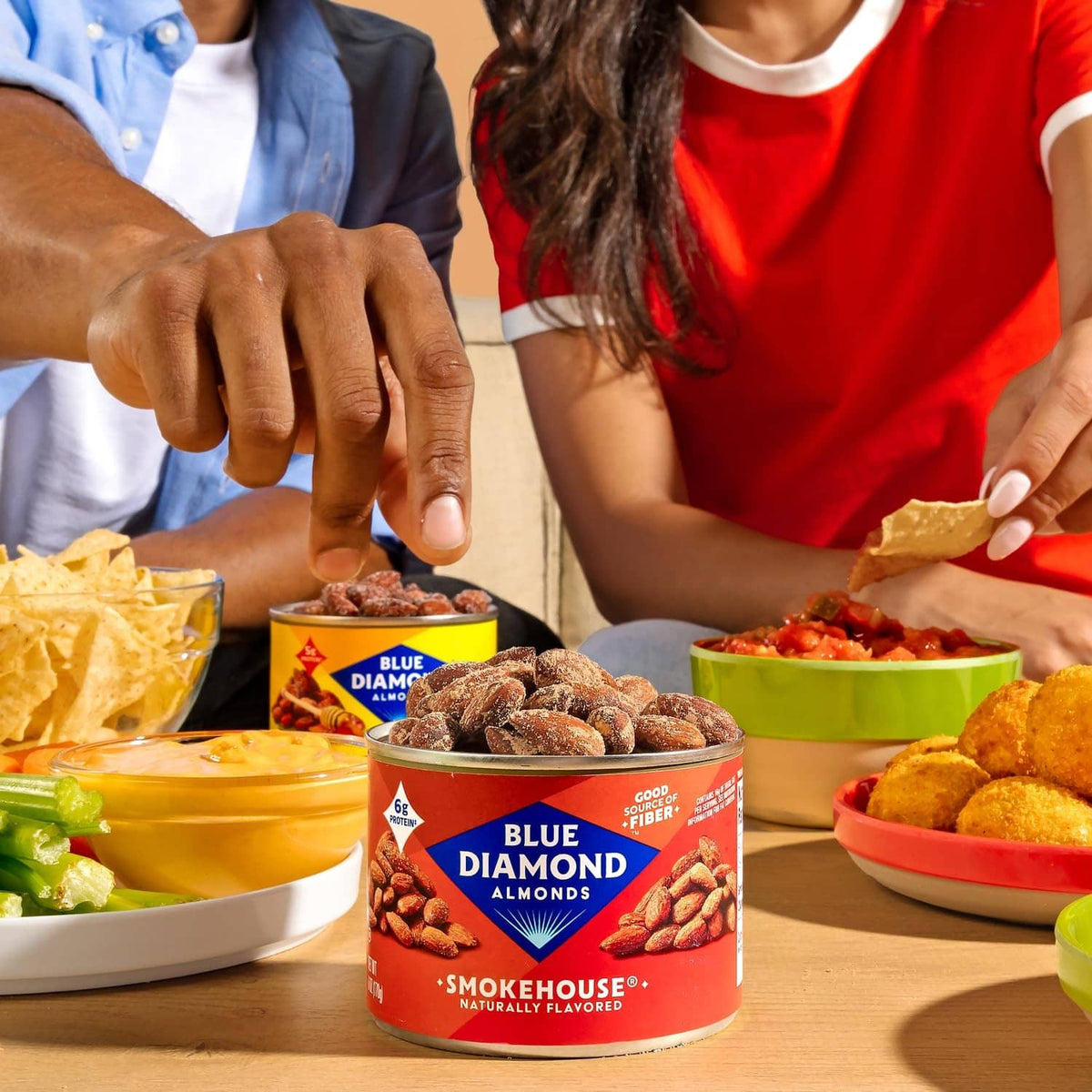 Blue Diamond lightly salted almonds container on a table with served snack bowls