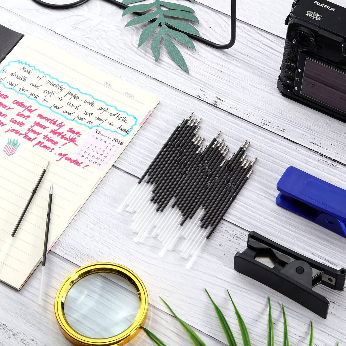 Pen refill set with 1 mm tips next to notebook, magnifier, and stapler