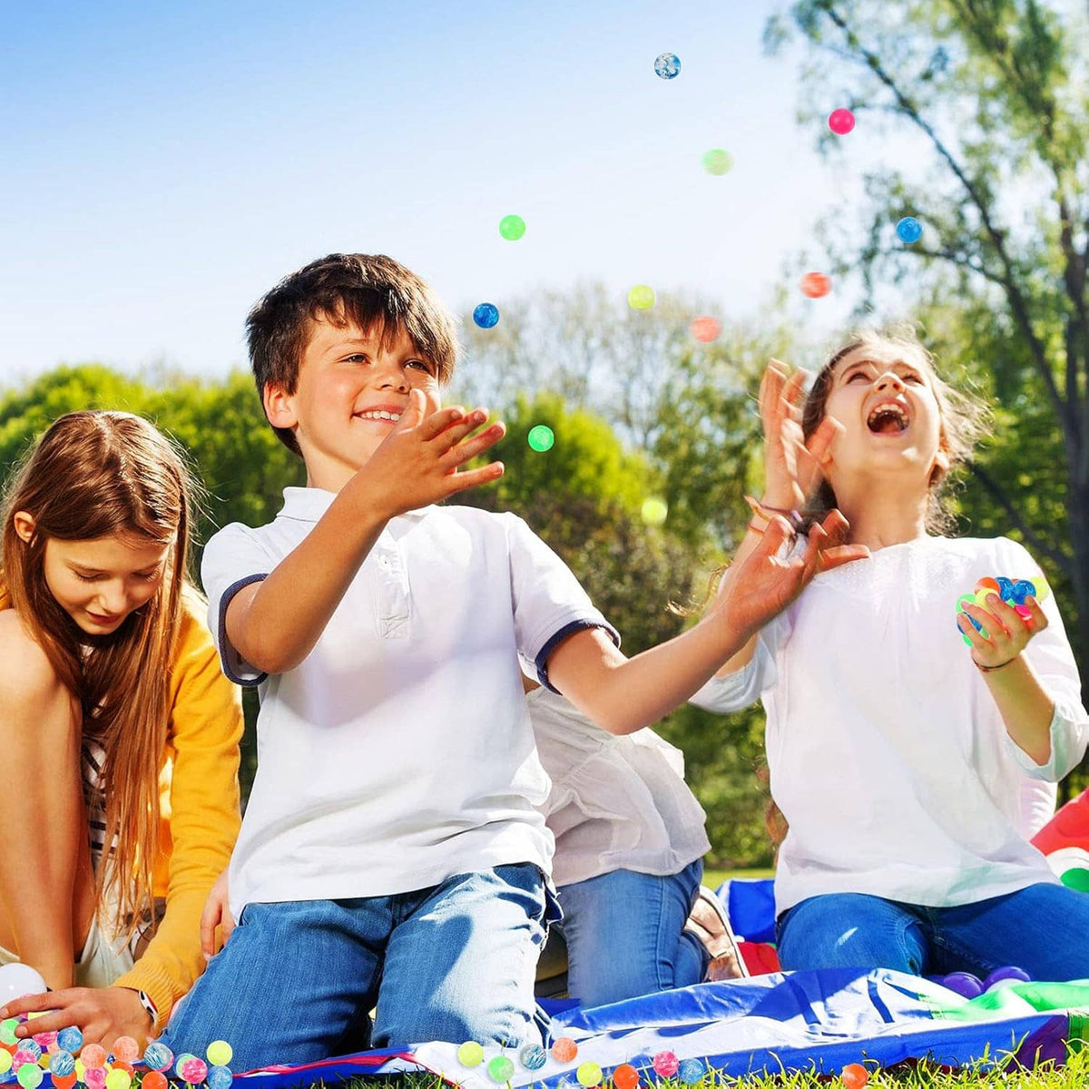 Colorful bouncy balls mid-air above kids during outdoor play.
