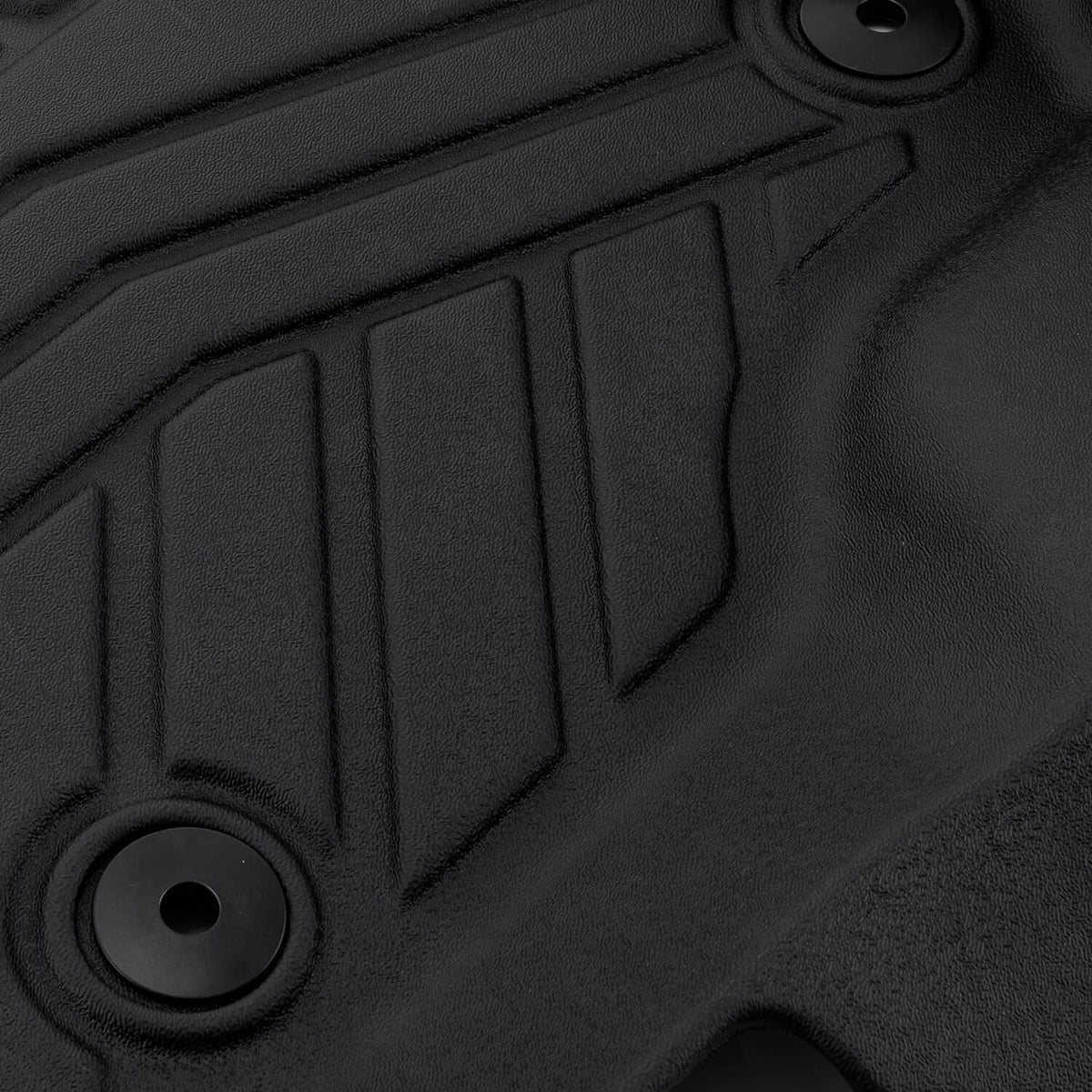 Close-up of black floor liner mat with molded button holes and ribbed texture