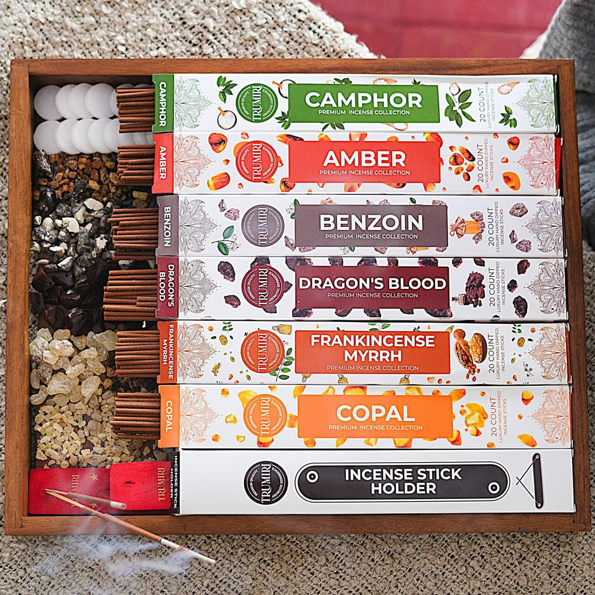 Wooden tray filled with Trumiri resinous incense stick packs and a holder