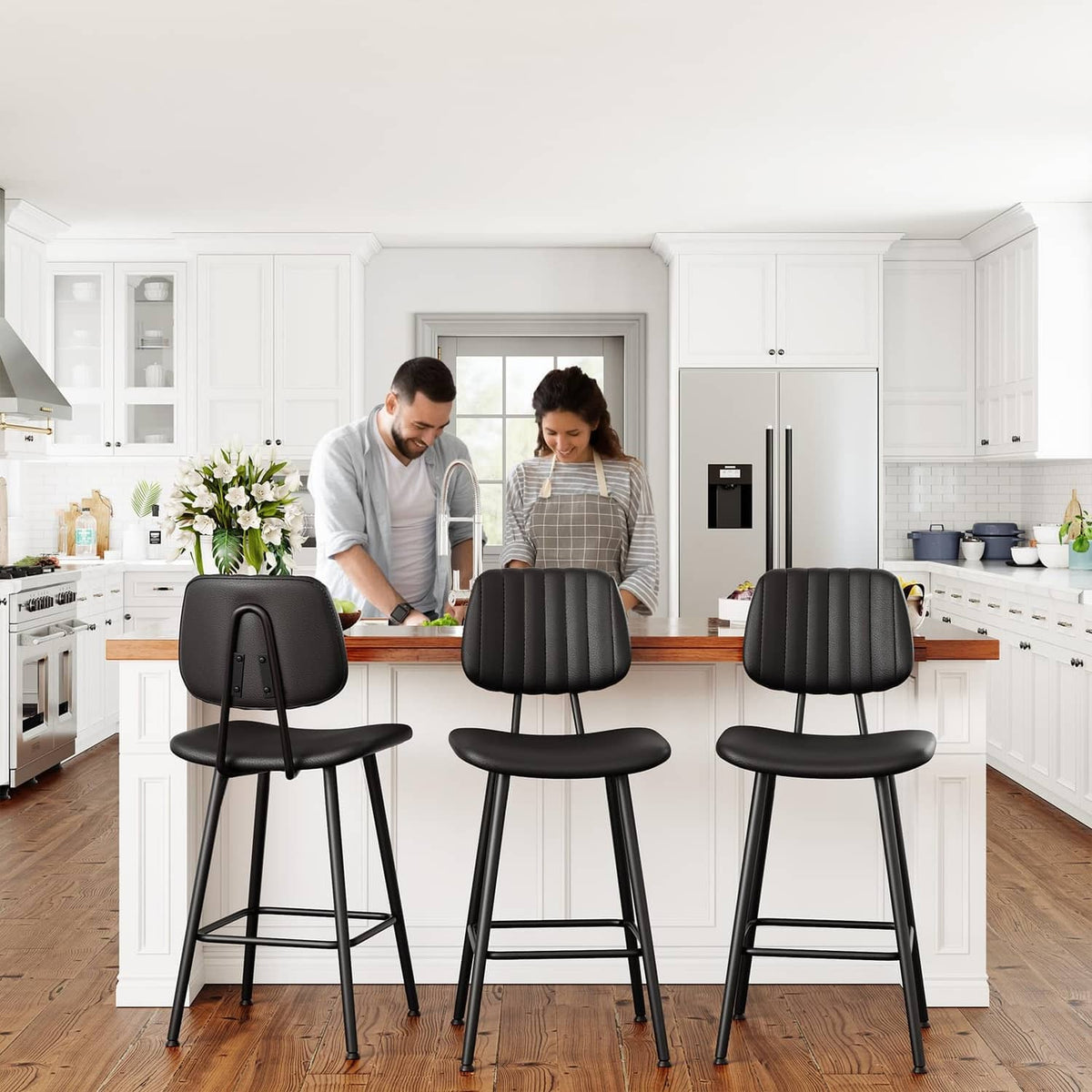 Three black counter-height bar stools with padded backs and cushioned seats in a kitchen.