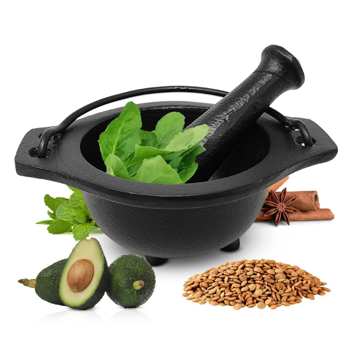 Black cast iron cauldron mortar and pestle with fresh leaves inside bowl