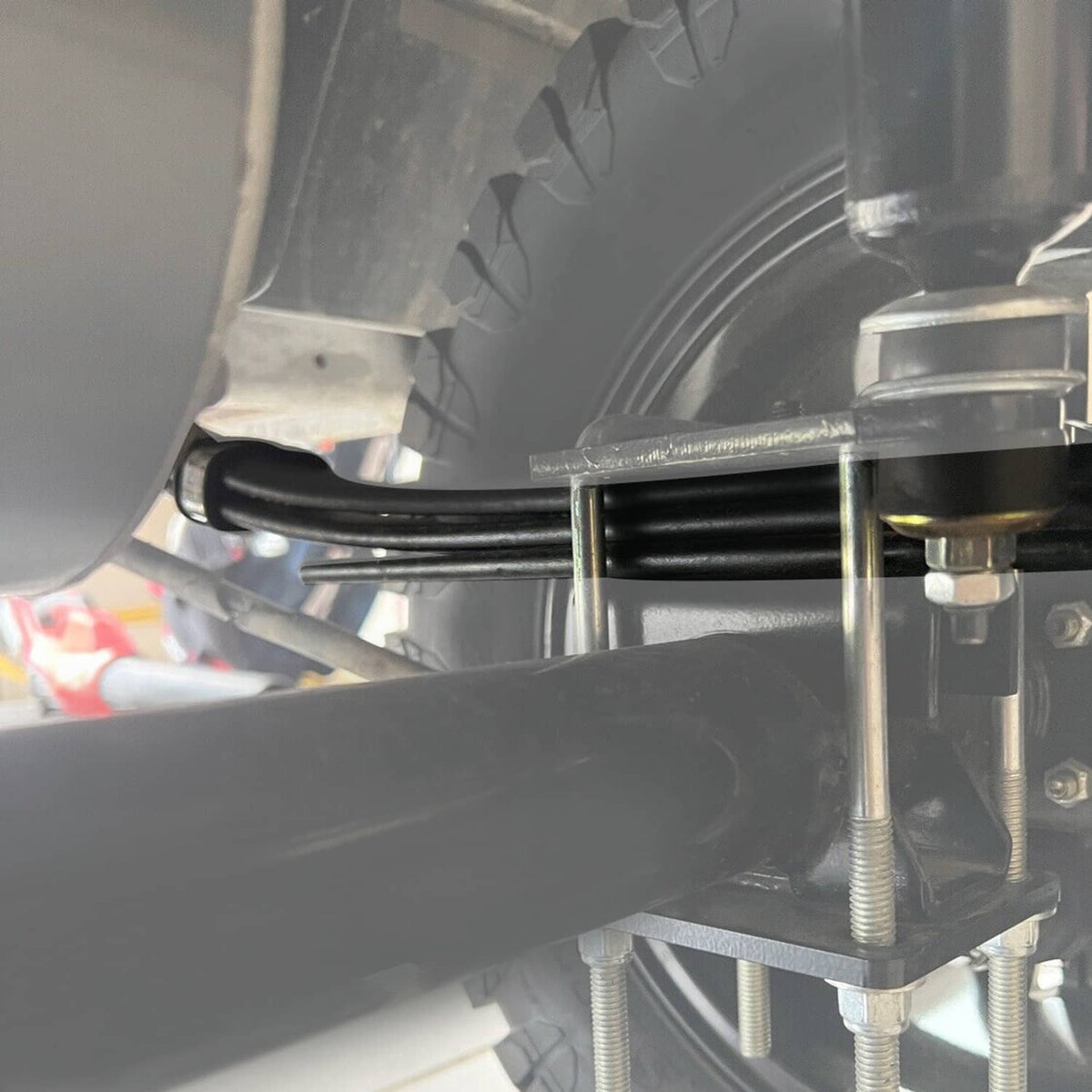 Close-up of black rear leaf spring bracket and bushing mount on golf cart chassis