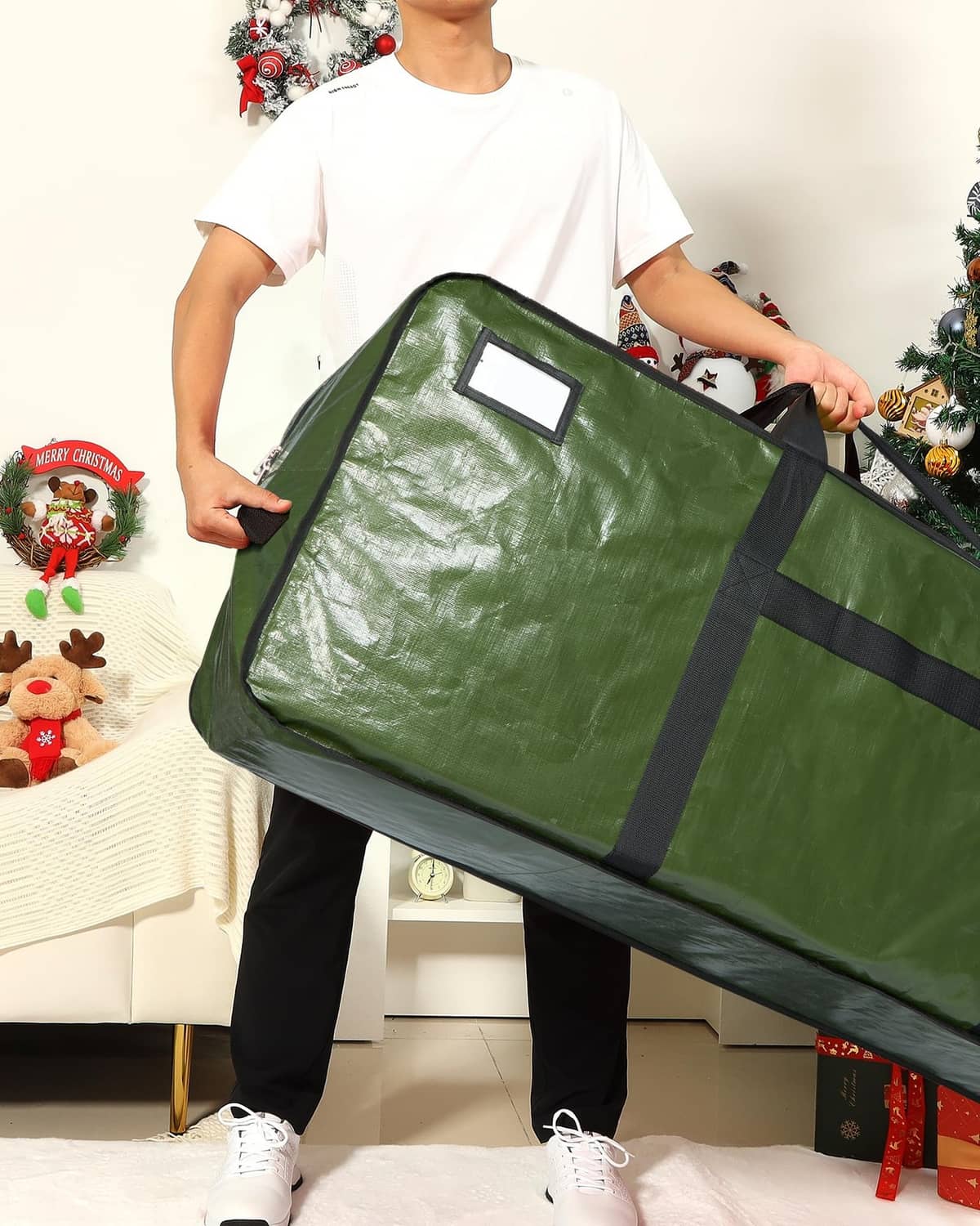 Green Christmas tree storage bag held by person, with window panel and side strap