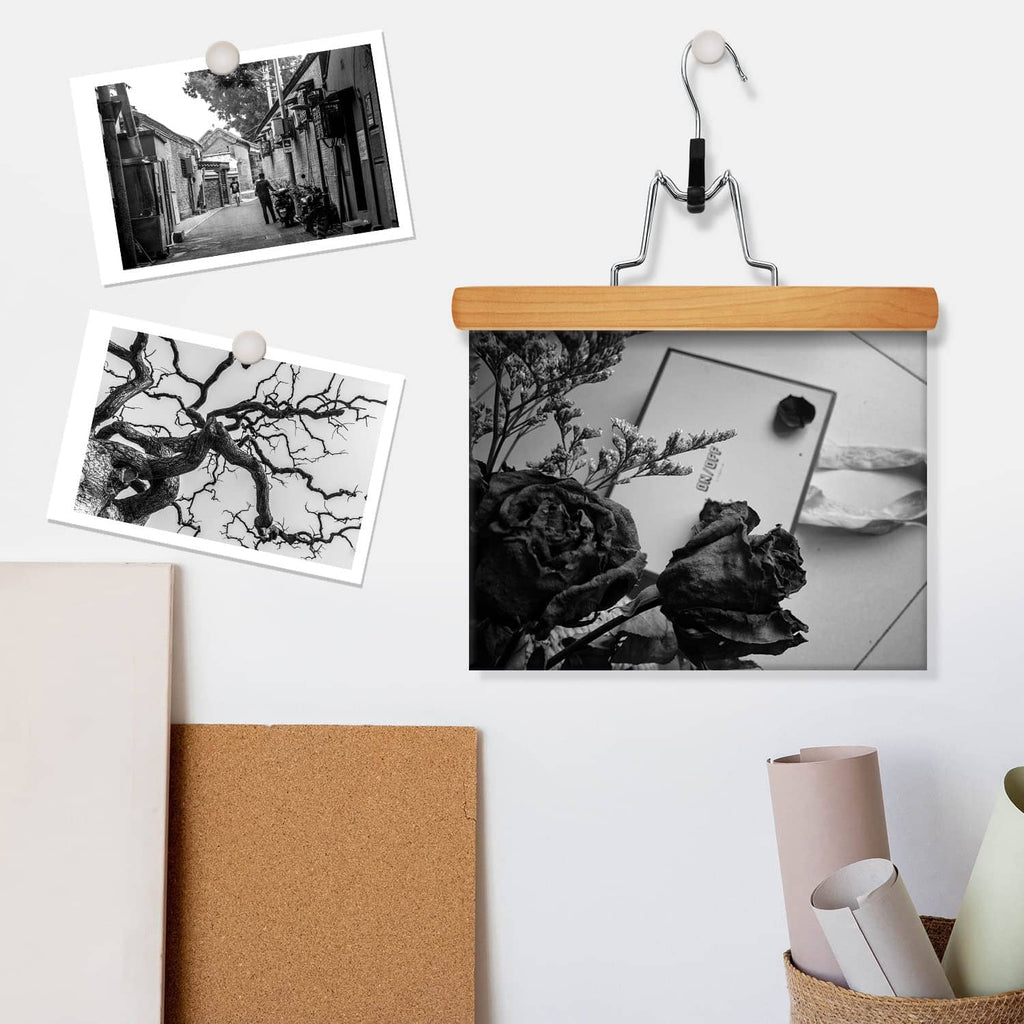 Natural wooden hanger with chrome hook, set against wall with decor photos
