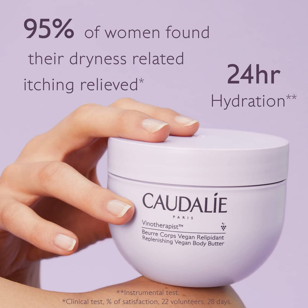 CAUDALIE body butter jar held by a hand, pale lavender container with white lid
