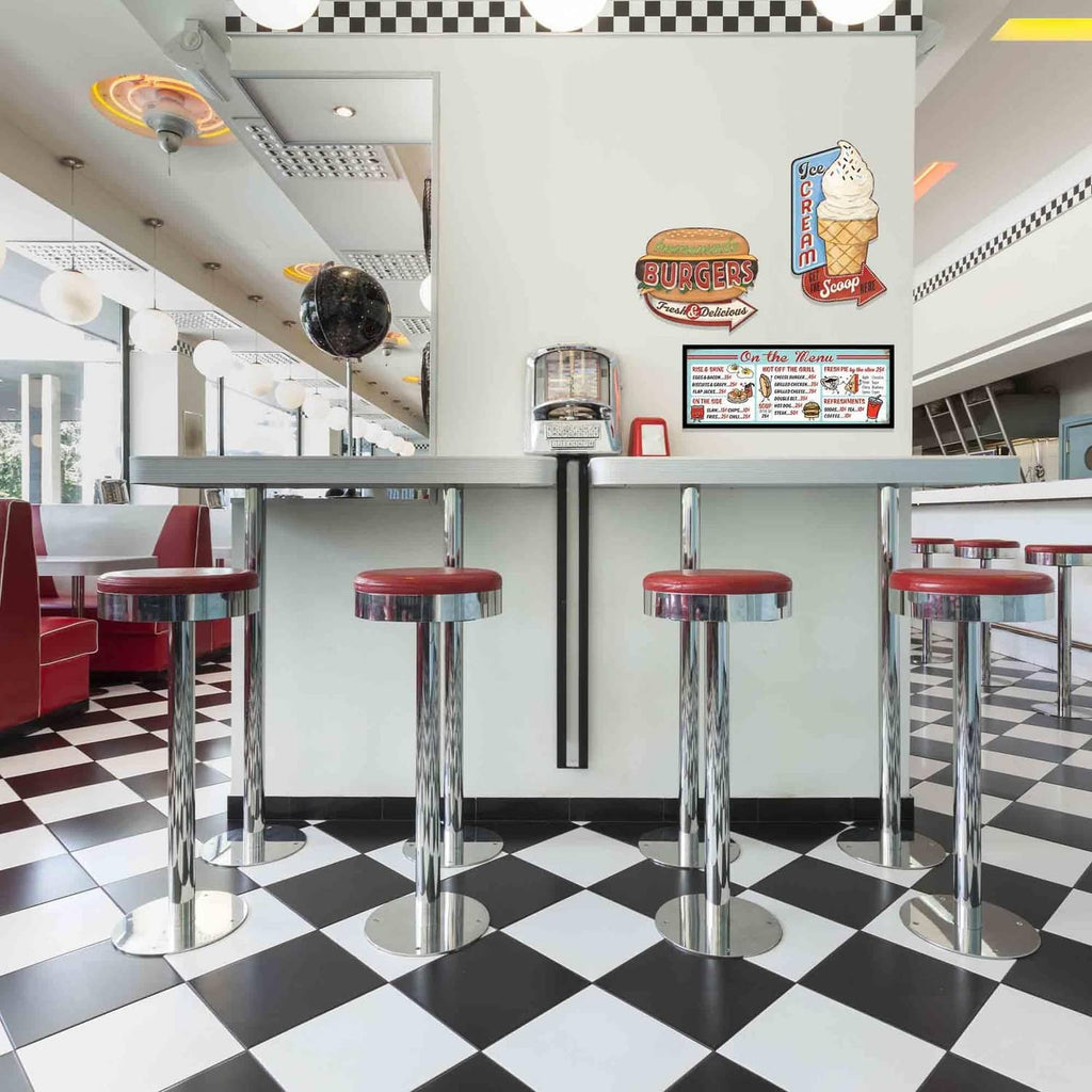 Diner-style metal menu sign on wall with “On the Menu” and colorful food sections