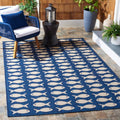 Outdoor washable rug in navy with beige fish pattern, rectangular flatweave.