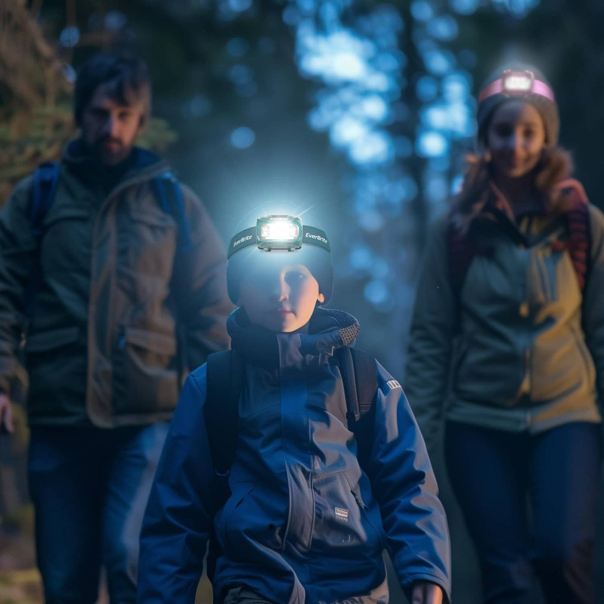 Child wearing a green headlamp with a bright white light during outdoor night