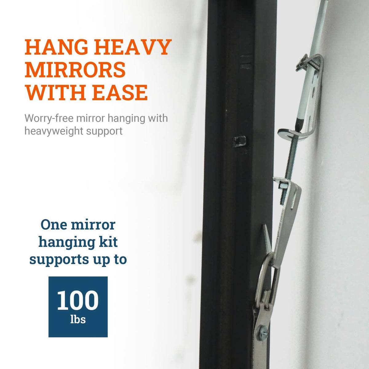 Mirror hanging hardware attached to a dark mirror frame edge with leveling screws