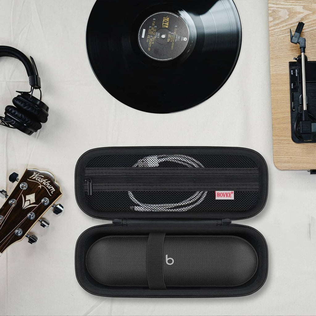 Black speaker carrying case open with coiled cable and speaker secured by elastic strap