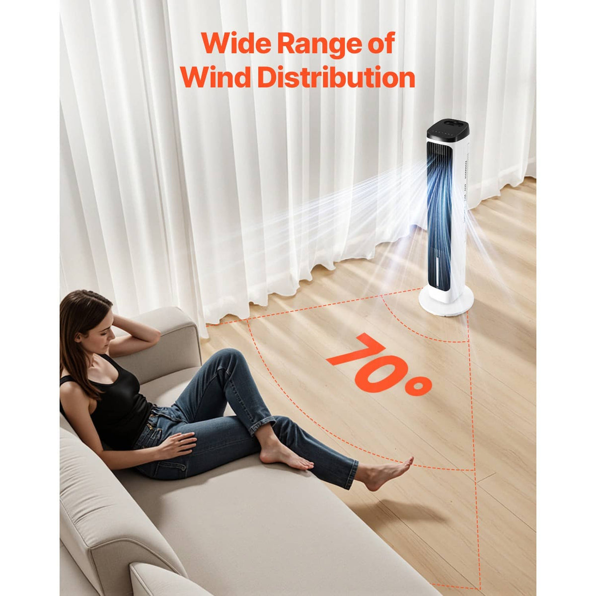 White tower fan with black grille, positioned for wide airflow toward a couch area