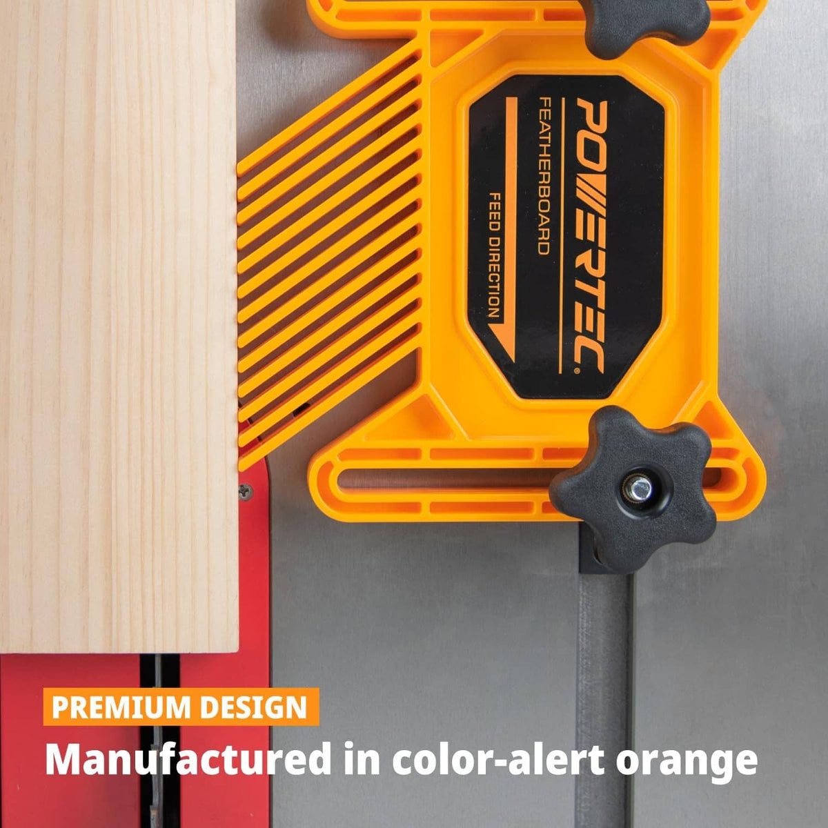 Orange featherboard clamp with black star knob holding work edge