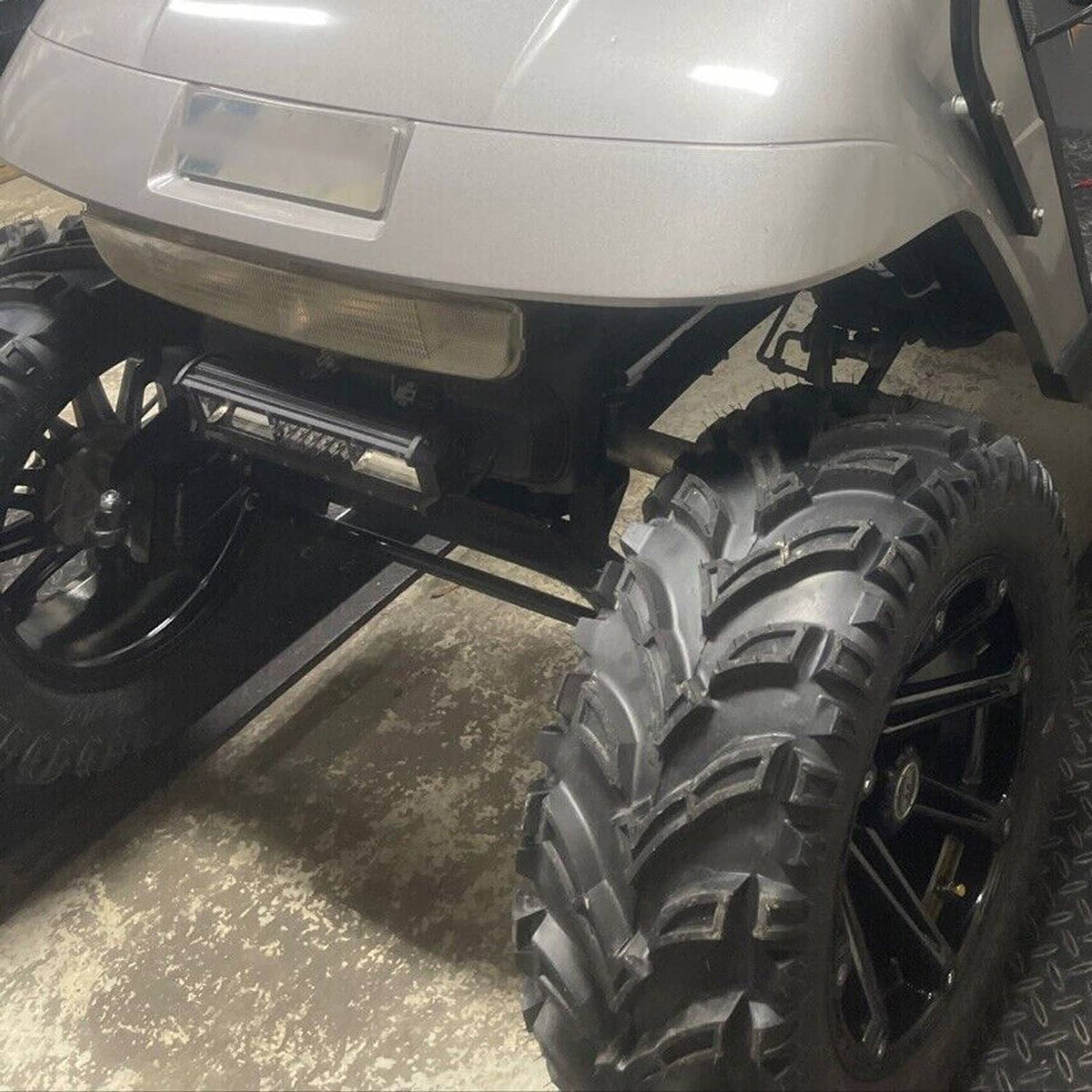 Lifted electric golf cart showing raised suspension and large off-road tires