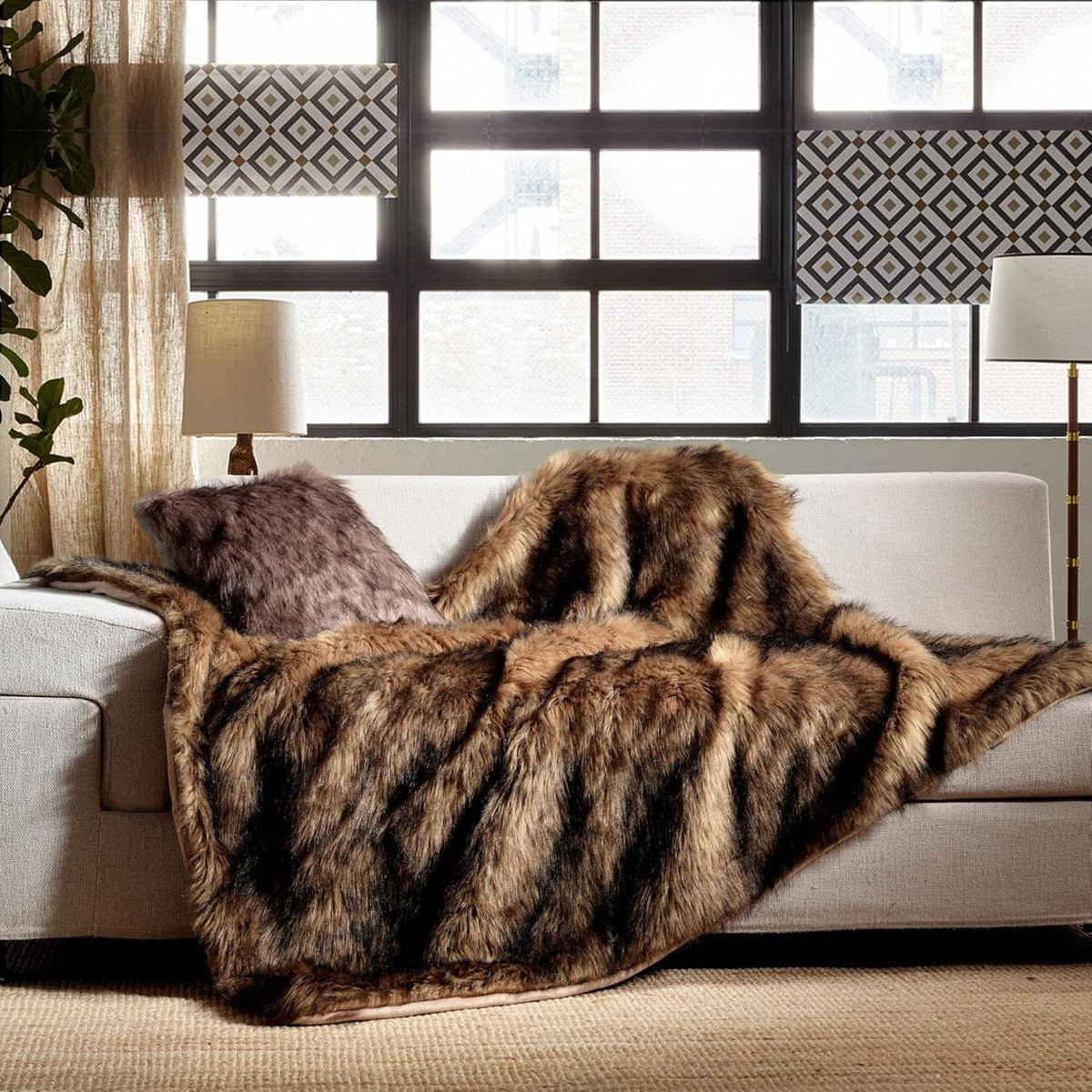 Brown faux fur blanket with black tips, long pile, folded over couch