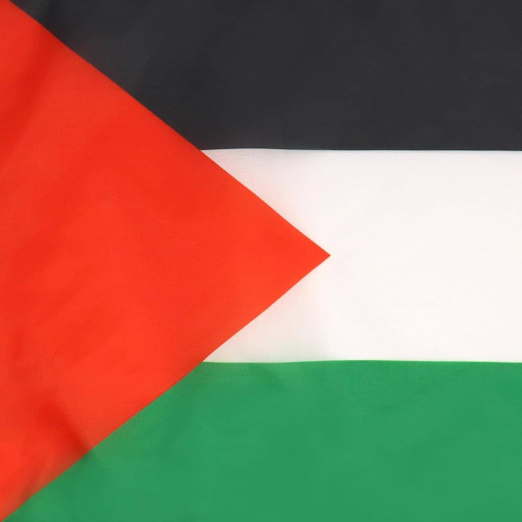 Close-up of Palestinian flag fabric: red triangle, black band, white stripe, green band