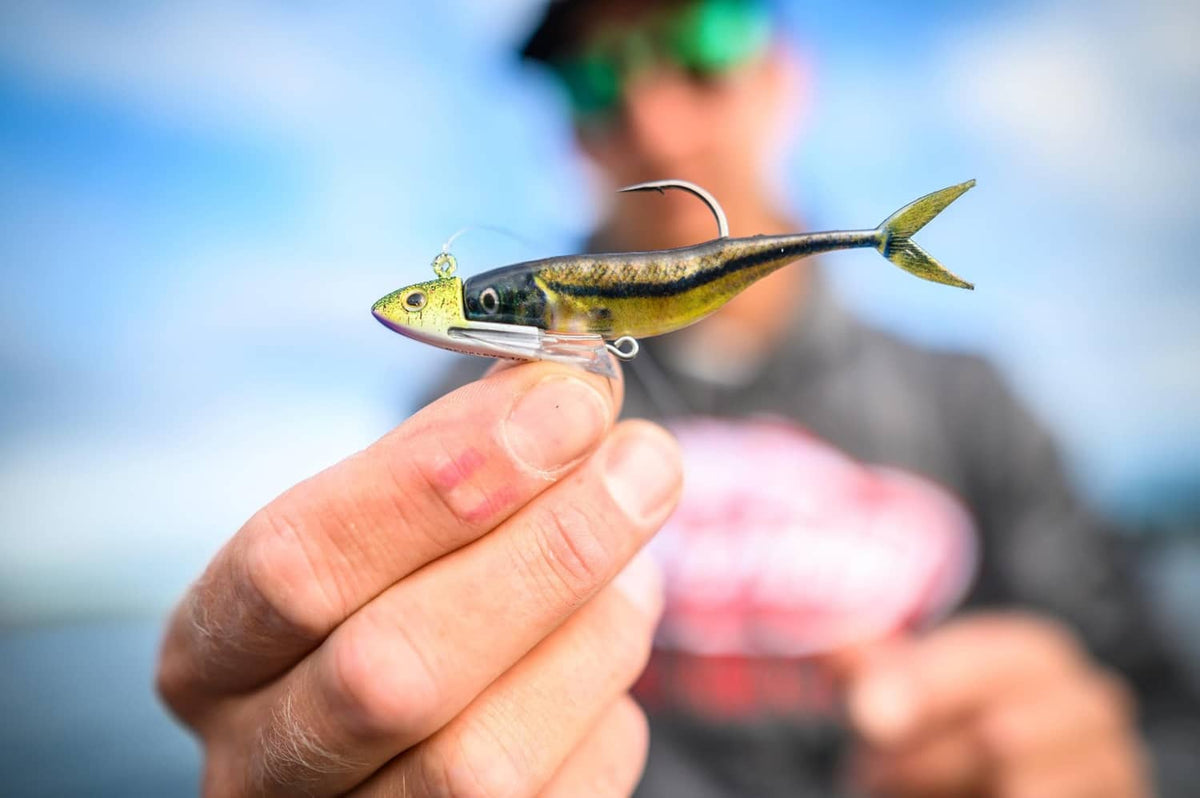Soft plastic minnow lure with yellow-green body, reflective scales, and treble hook