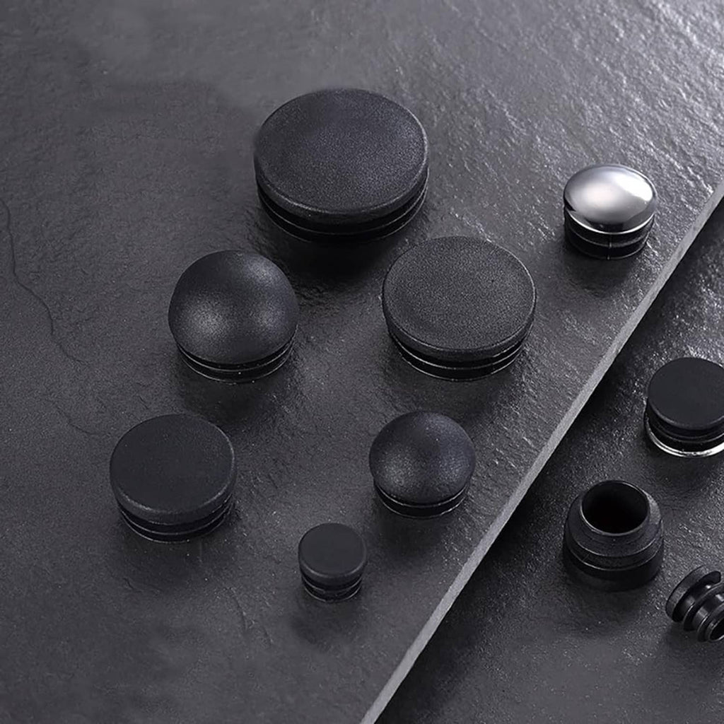 Assorted black plastic chair leg end caps and plugs with rounded tops