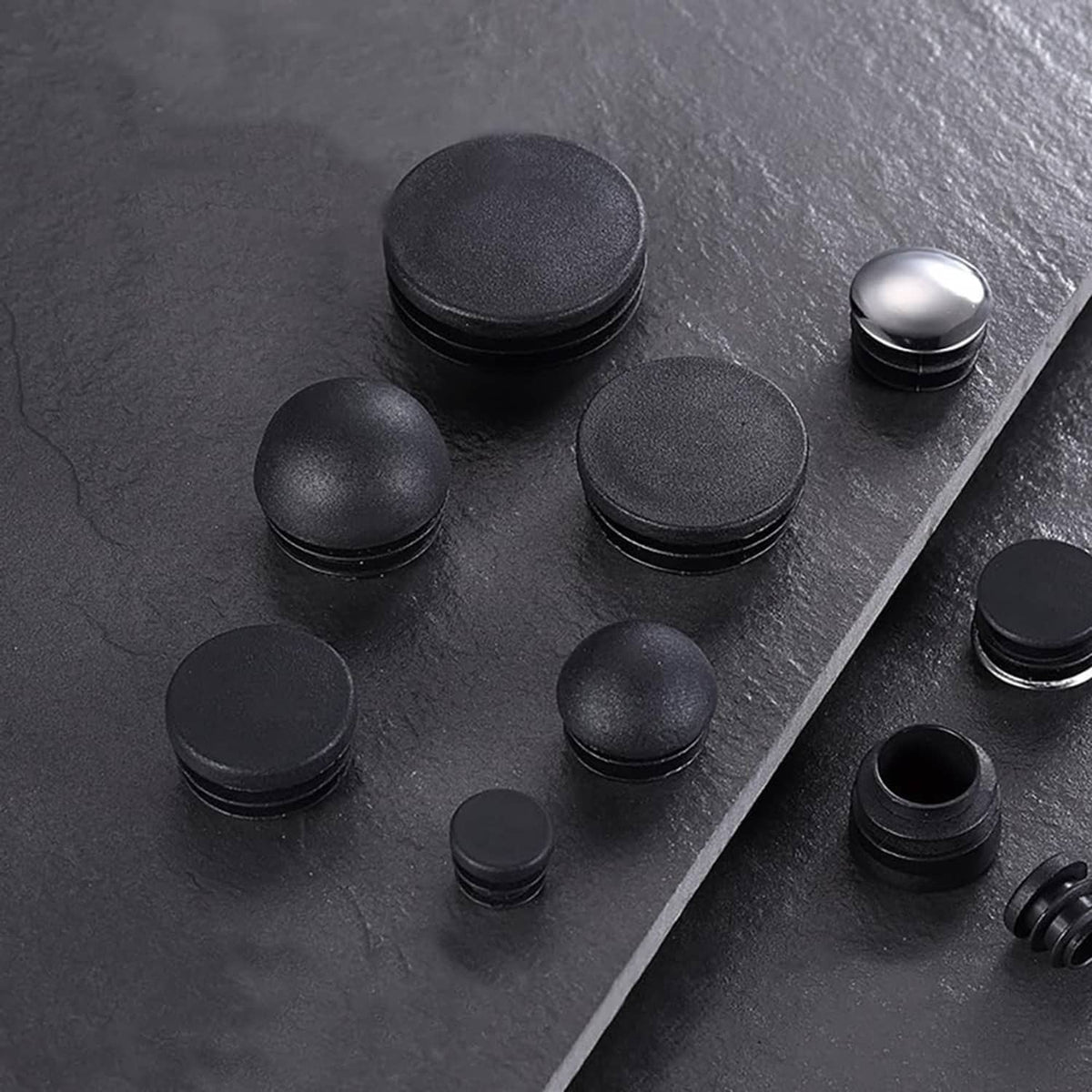 Assorted black plastic chair leg end caps and plugs with rounded tops