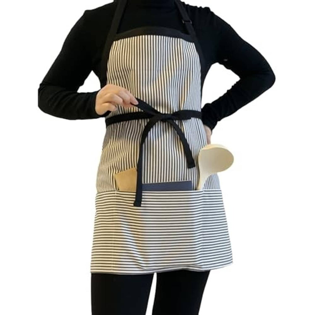 Black long-sleeve top with striped apron overlay, black neck straps, and waist tie