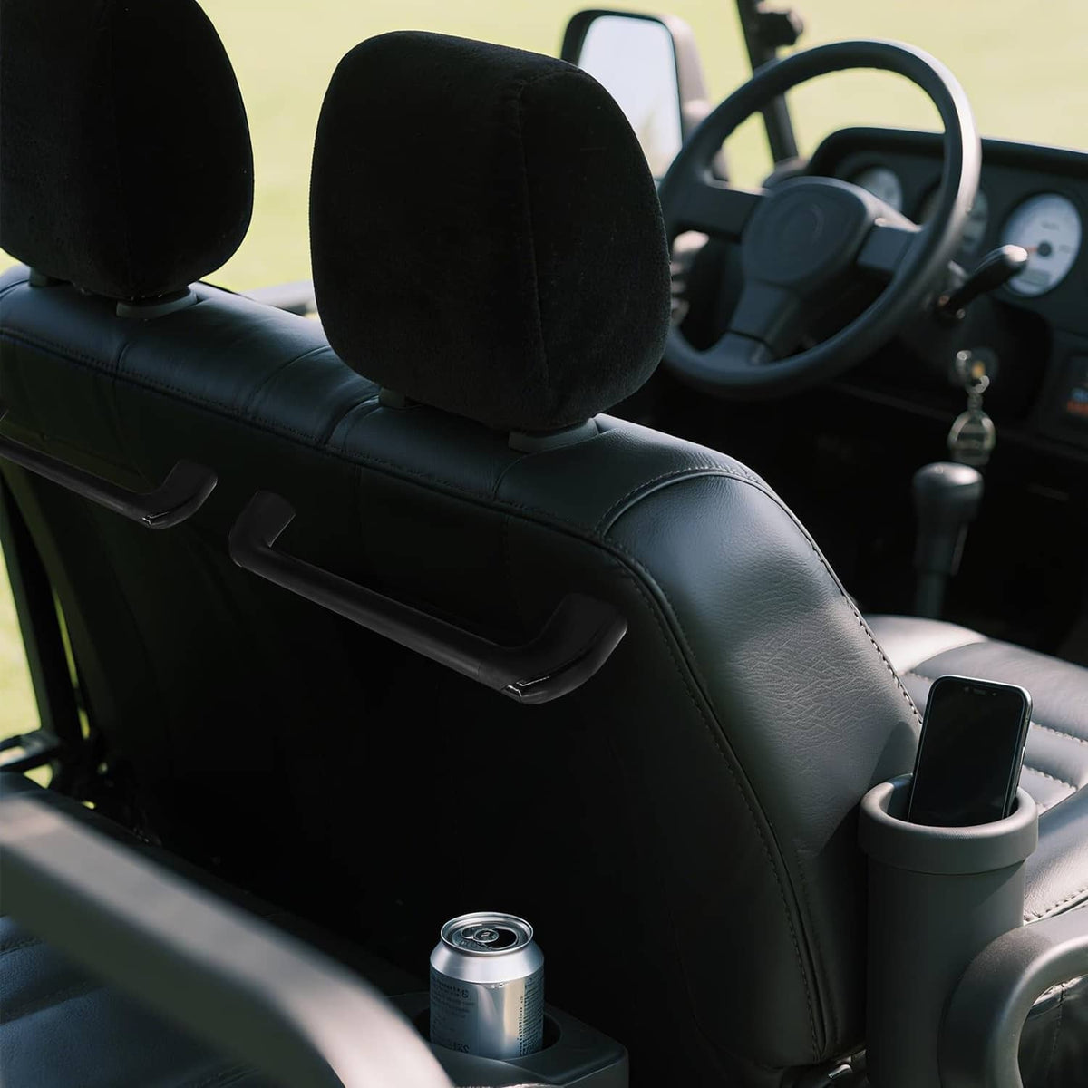 Black curved grab handle mounted on golf cart near steering wheel and seat