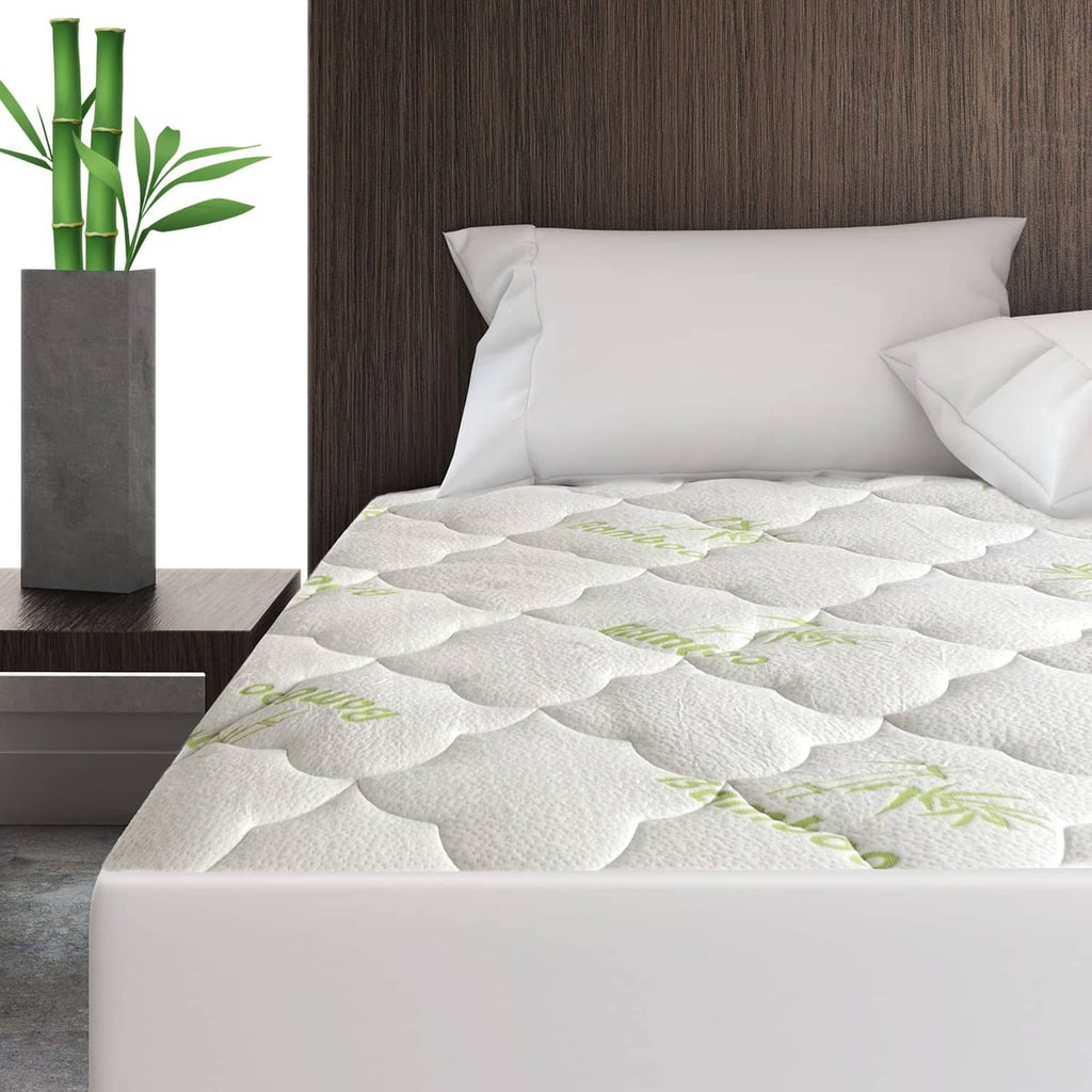 White quilted mattress pad cover with green bamboo pattern, fitted on mattress top