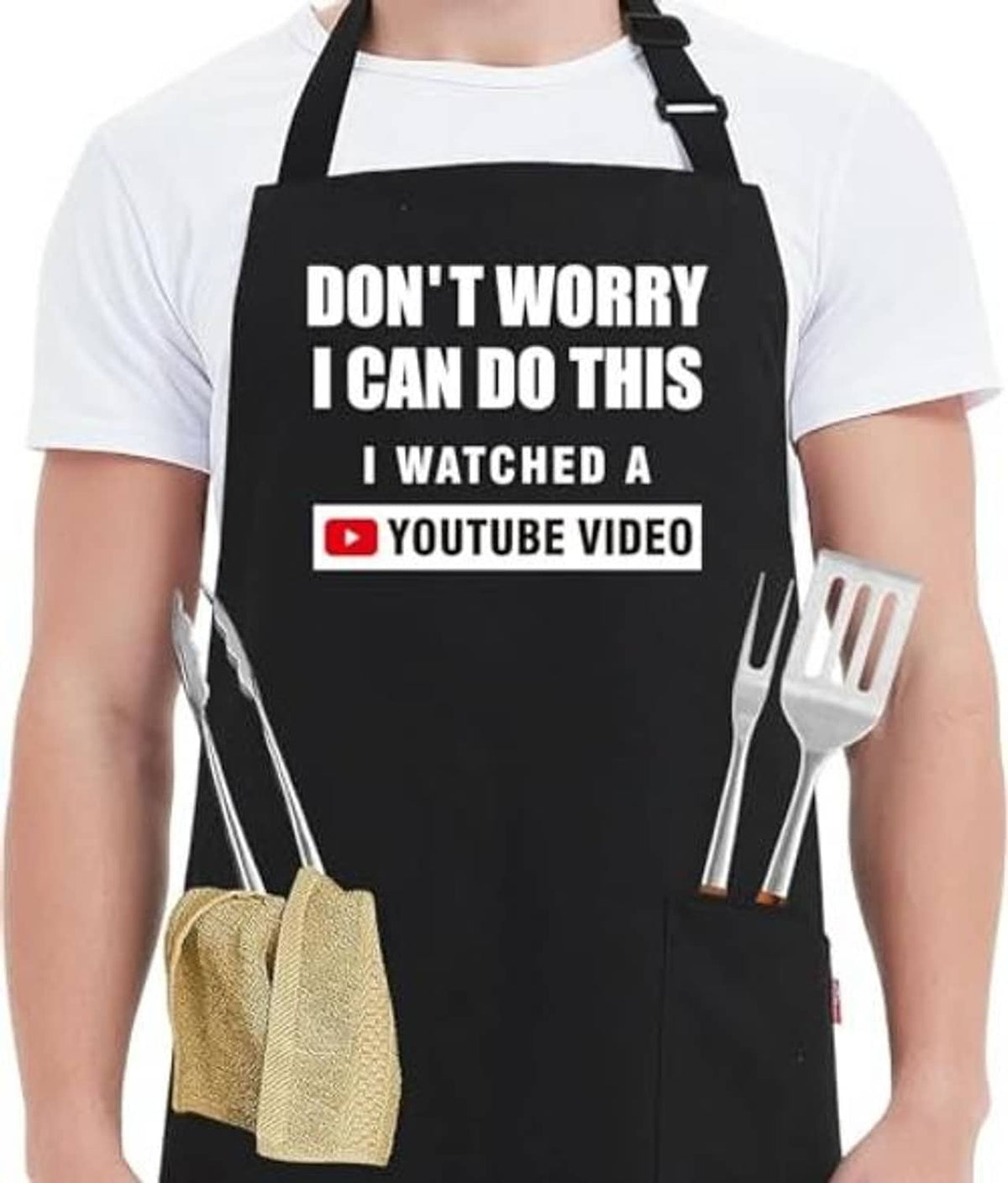 Black kitchen apron with bold quote and YouTube video badge, adjustable neck strap shown