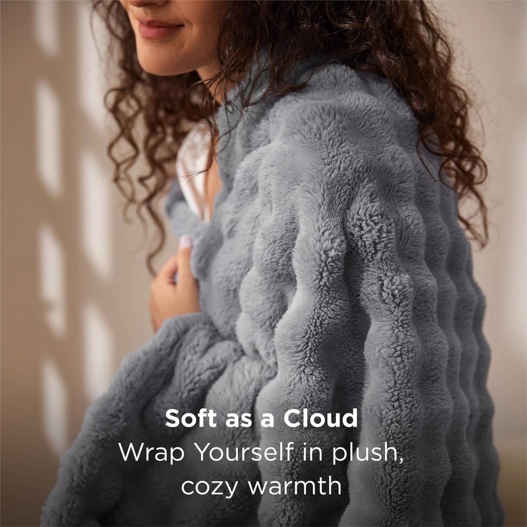 Gray bubble fleece blanket with raised 3D texture, draped over a person
