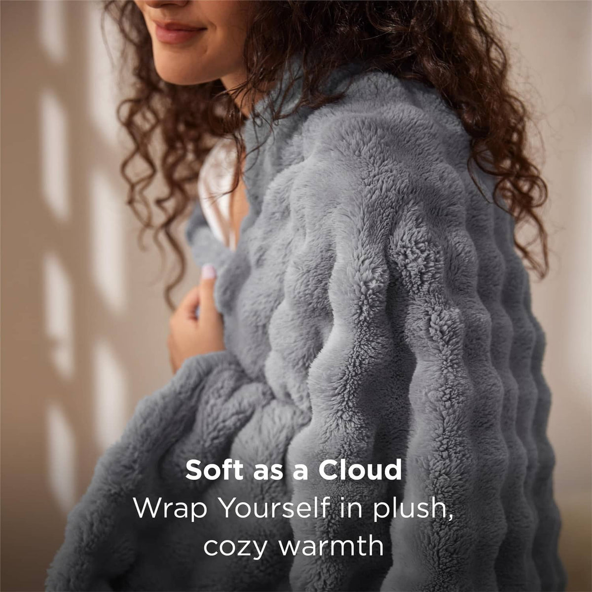 Gray bubble fleece blanket with raised 3D texture, draped over a person