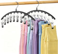 Metal arched legging organizer with clips holding folded colorful pants