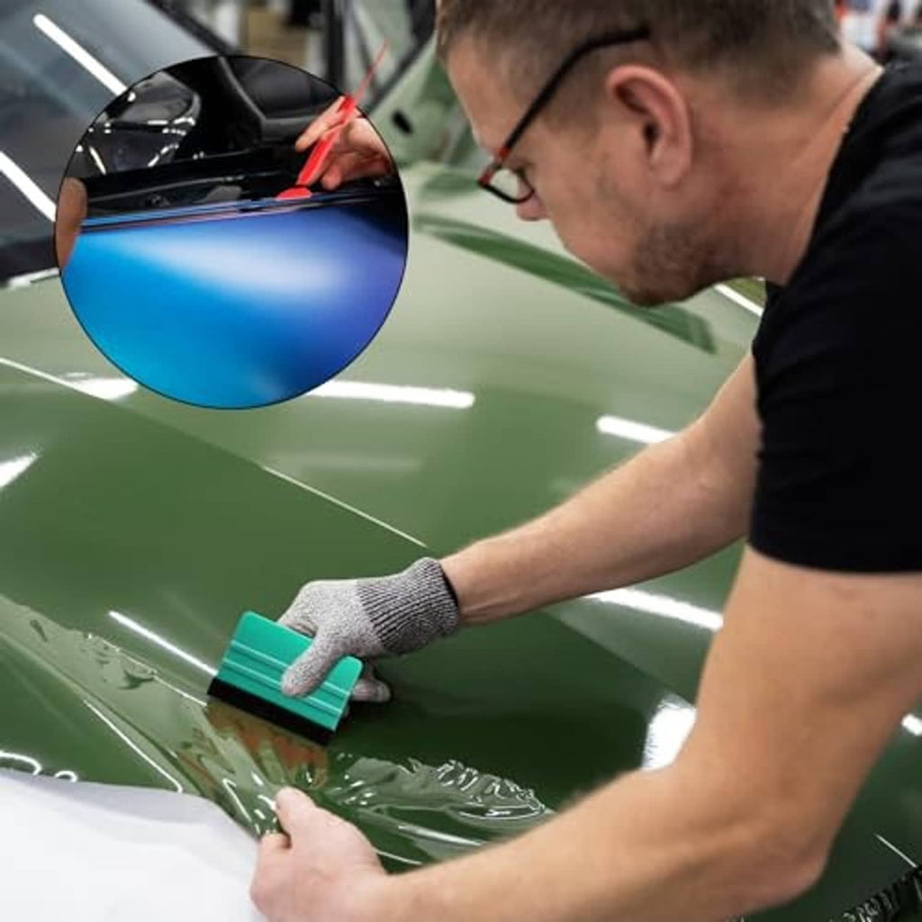 Vinyl wrap squeegee tool with felt pad in use on glossy green vehicle film