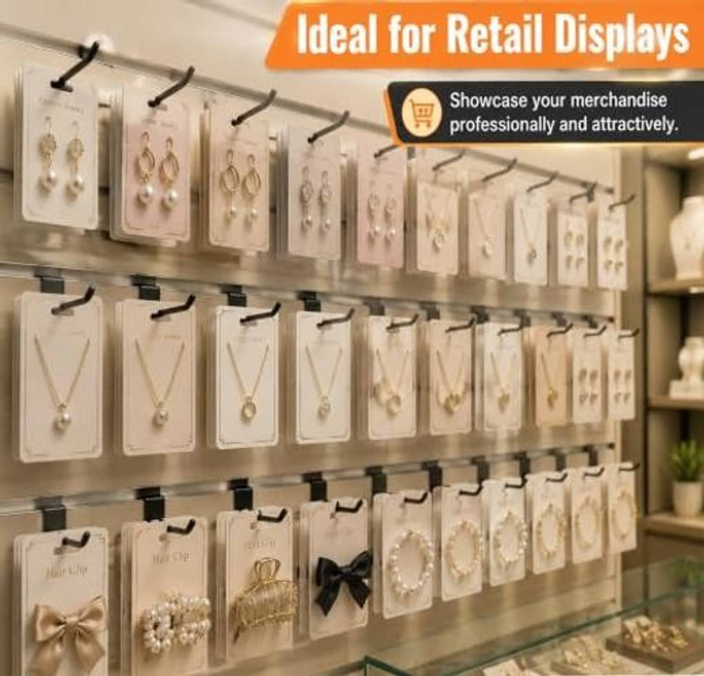 Black slatwall hooks on a retail display rail, holding necklaces and small items