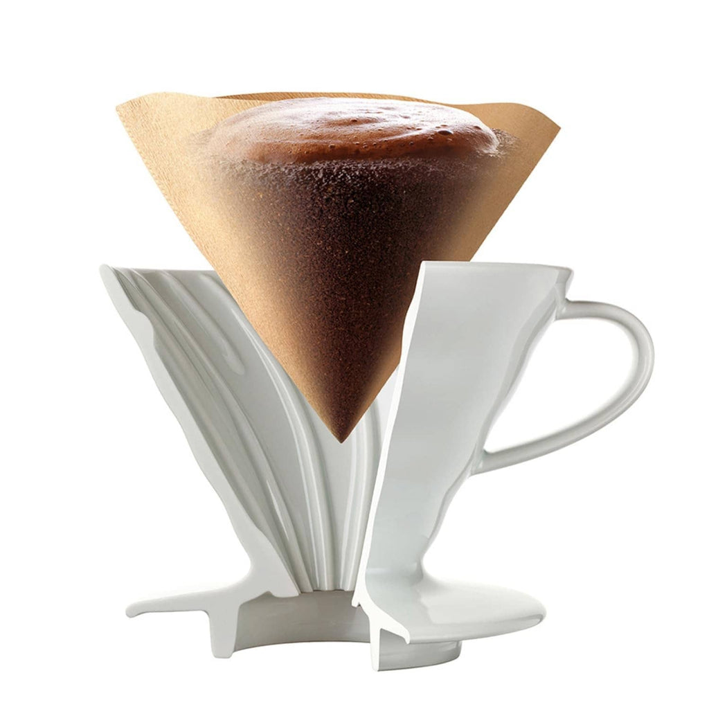 White paper coffee filter with coffee grounds on a dripper