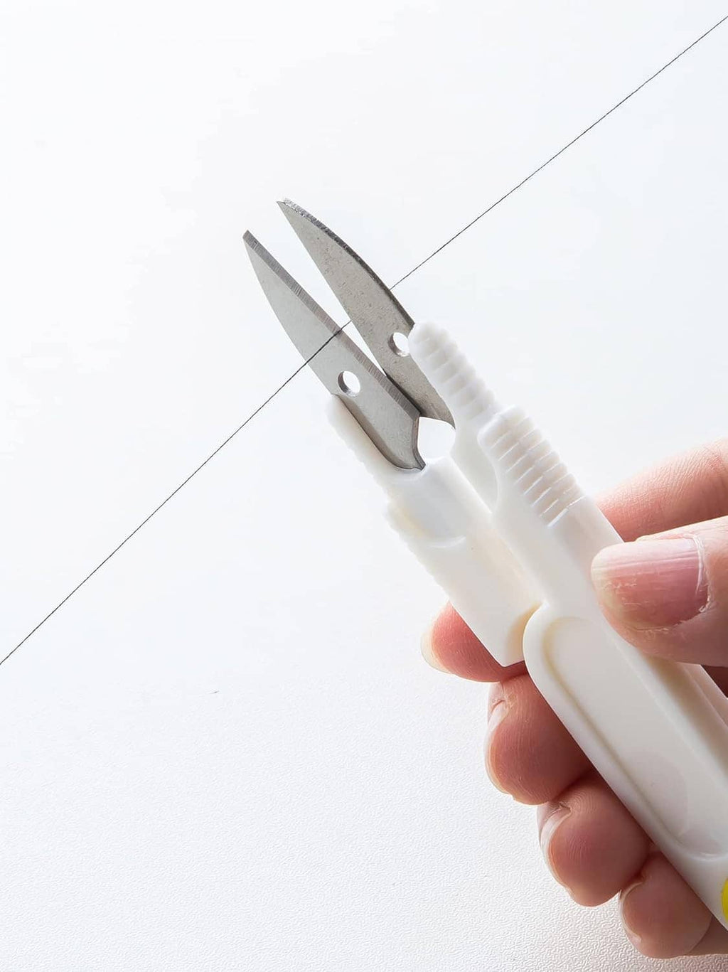White thread remover tool with two metal blades for quick cutting