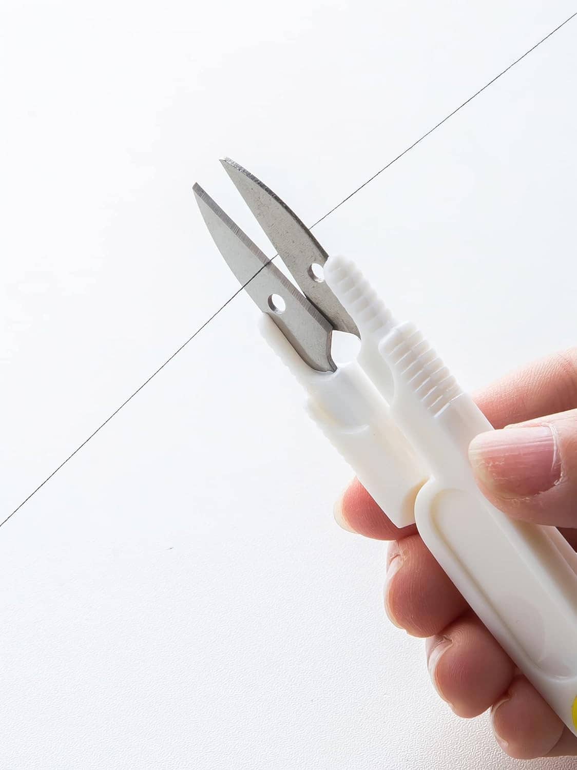 White thread remover tool with two metal blades for quick cutting