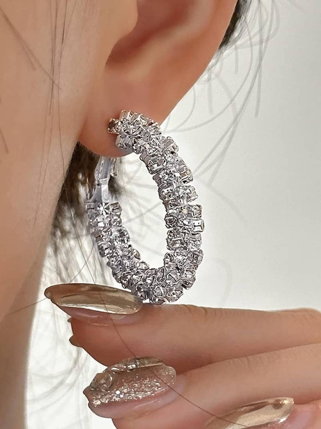 Silver-toned small hoop earrings with clustered sparkling stones and hinge closure