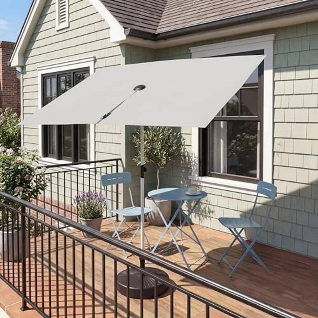 Open beige rectangular balcony umbrella on a deck with metal support stand