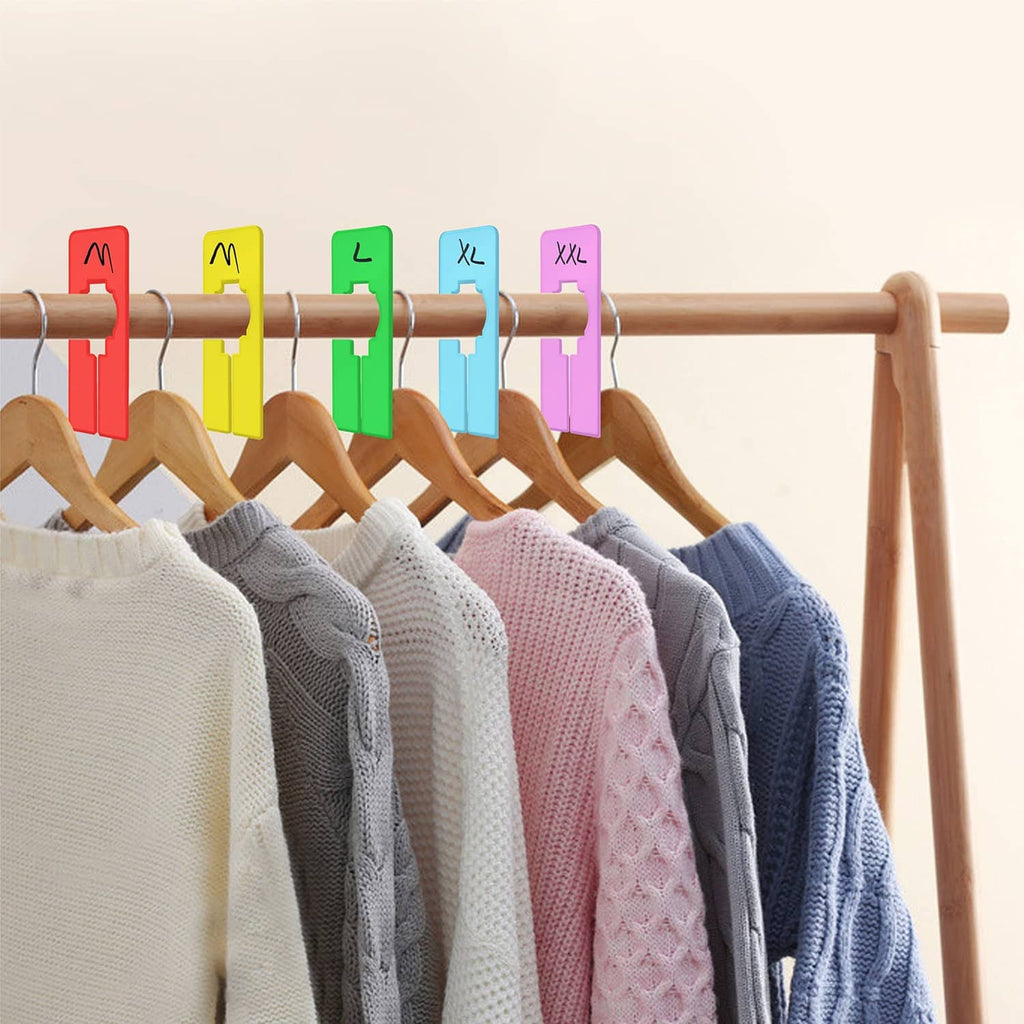 Closet rod with multiple colored rack dividers and folded sweaters hanging