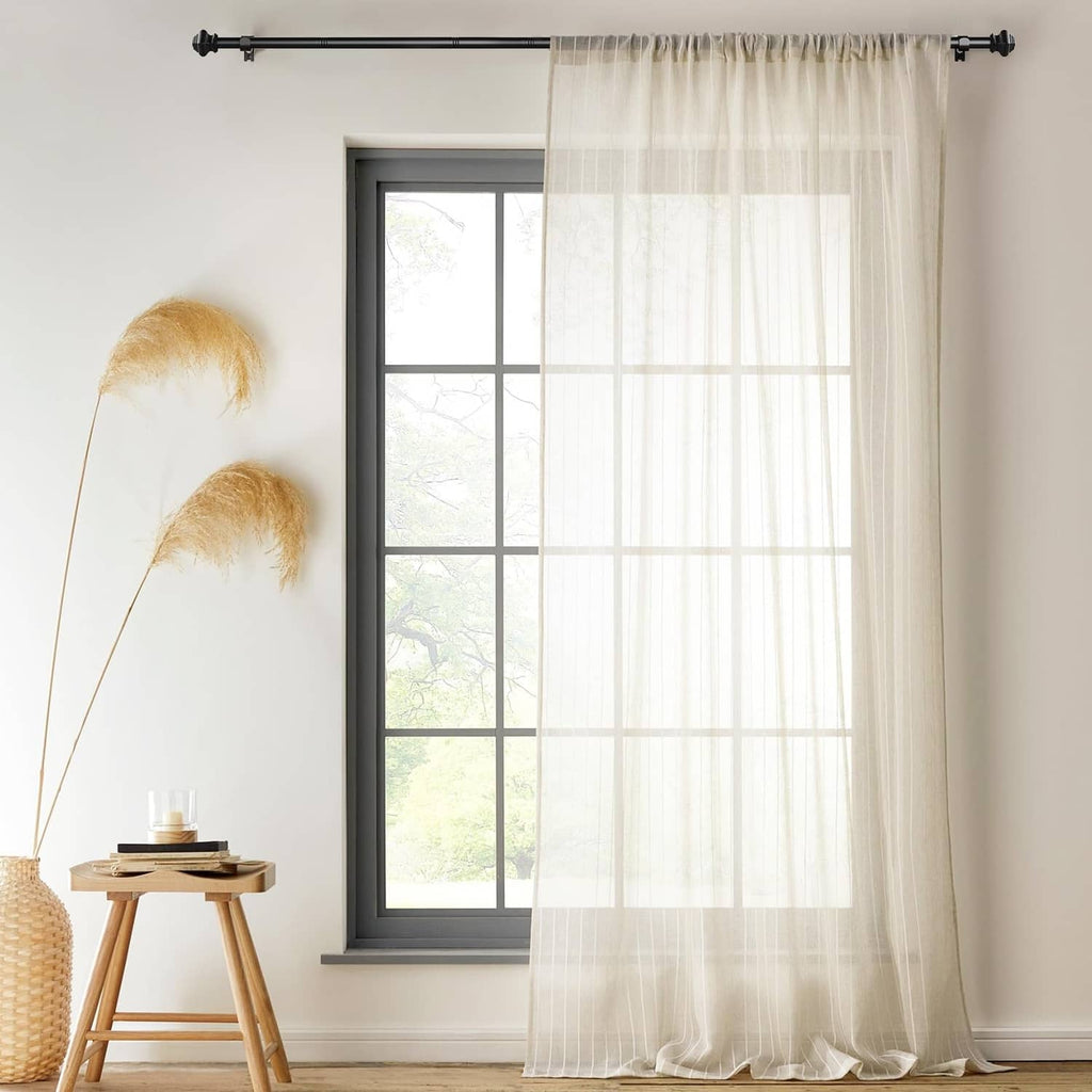 Matte black curtain rod installed above sheer white curtains