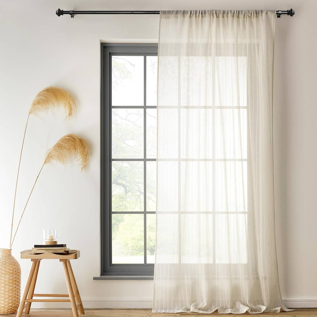 Matte black curtain rod installed above sheer white curtains