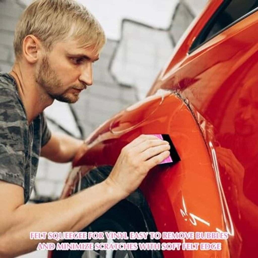 Pink felt squeegee tool with black edge pad being pressed to a car