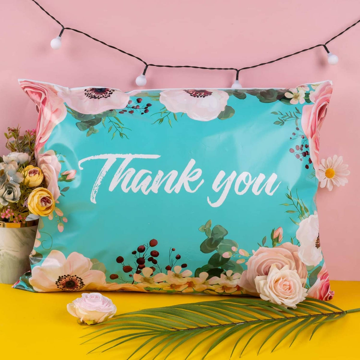 Turquoise floral poly mailer with 'Thank you' white script and flower border
