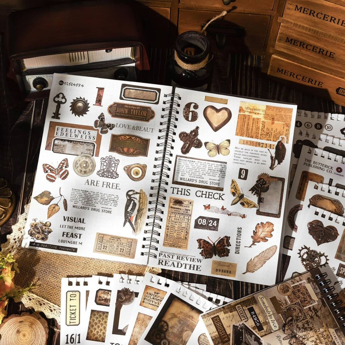 Vintage-style washi sticker sheets with hearts, tickets, clocks, and butterflies in a notebook