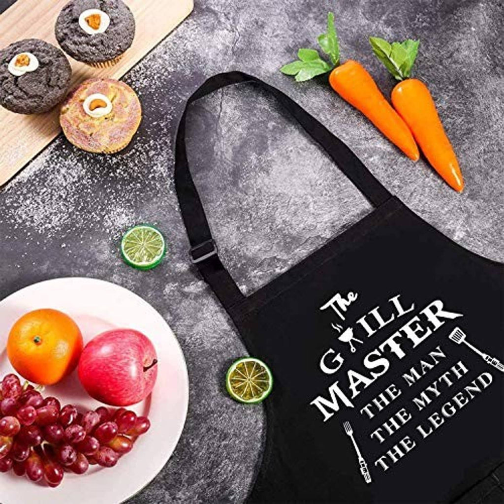 Black apron with grill-themed text graphic and neck straps, laid flat.